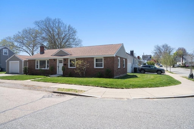 single story home with brick siding, driveway, a chimney, and a front yard