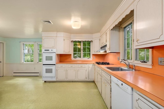 kitchen with white cabinets, white appliances, a baseboard heating unit, and sink