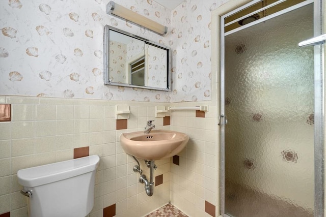 bathroom with an enclosed shower, tile walls, and toilet