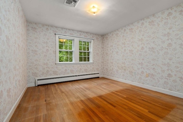 spare room with hardwood / wood-style floors and baseboard heating