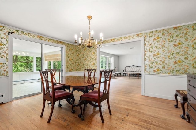 dining room featuring light hardwood / wood-style floors, crown molding, and a chandelier