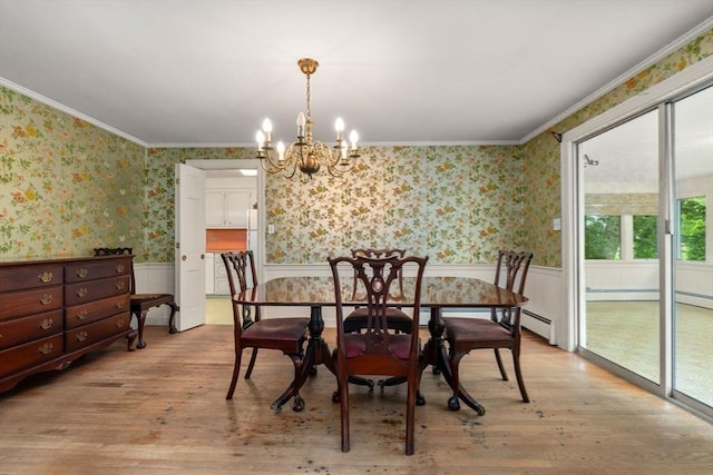 dining room with a chandelier, light wood-type flooring, and crown molding