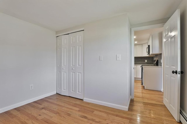 unfurnished bedroom with light hardwood / wood-style floors and a closet