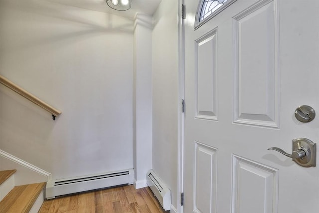 interior space with wood-type flooring and a baseboard heating unit