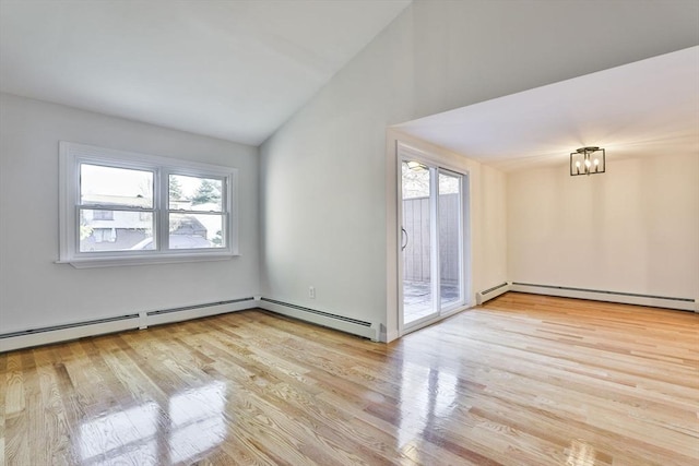 spare room featuring baseboard heating, light hardwood / wood-style floors, and lofted ceiling