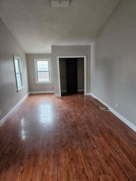 48-50 S Westfield St, Agawam, MA 01030 - unfurnished living room with dark wood finished floors, vaulted ceiling, and baseboards