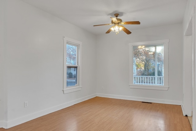 spare room with ceiling fan, a wealth of natural light, and light hardwood / wood-style floors