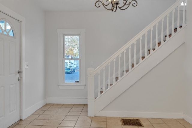 foyer entrance with a chandelier and light tile patterned flooring