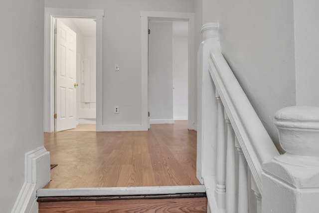 corridor featuring wood-type flooring and ornate columns