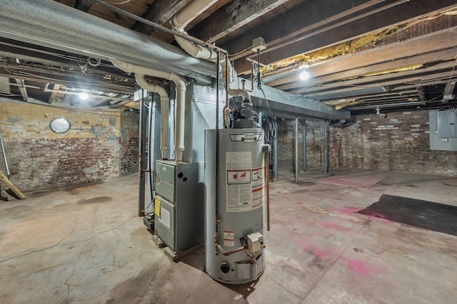 basement featuring water heater and brick wall