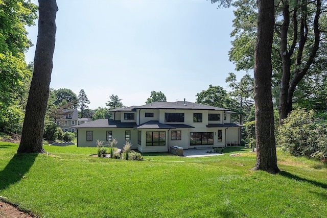 back of property featuring a lawn and a patio