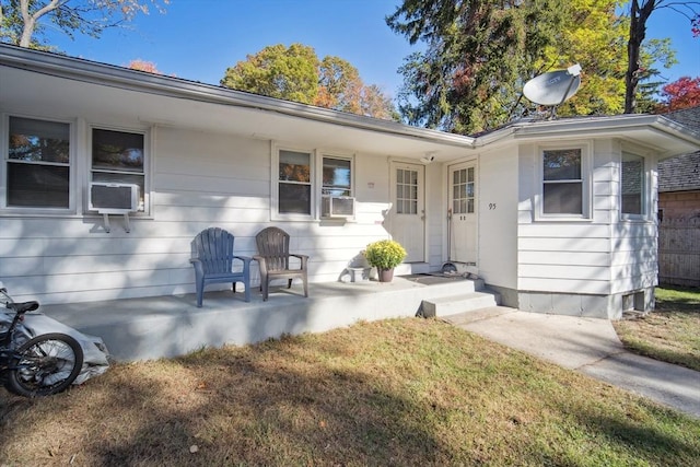 view of front of property featuring cooling unit and a front lawn