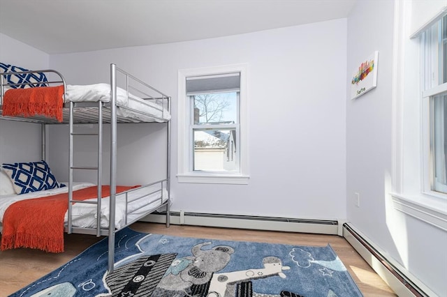 bedroom featuring baseboard heating and hardwood / wood-style flooring