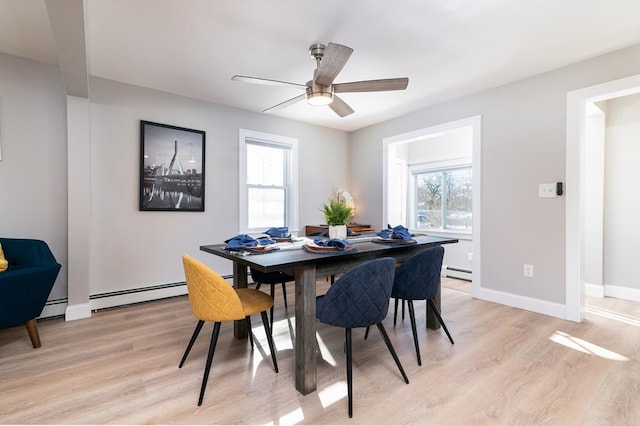 dining room with baseboard heating, ceiling fan, light hardwood / wood-style flooring, and a wealth of natural light