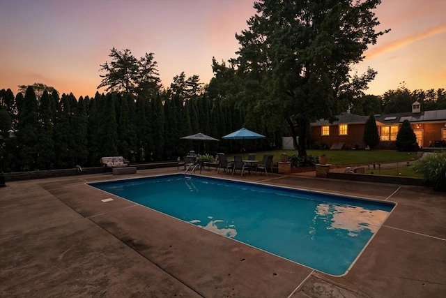 644 Stony Hill Rd, Wilbraham, MA 01095 - pool at dusk featuring a patio, an outdoor pool, a yard, and outdoor dining space