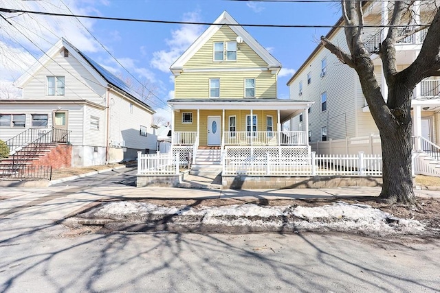 view of front of house featuring covered porch and fence