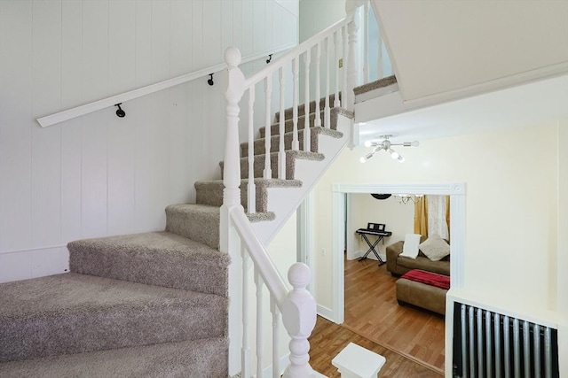 stairway featuring radiator heating unit and wood finished floors