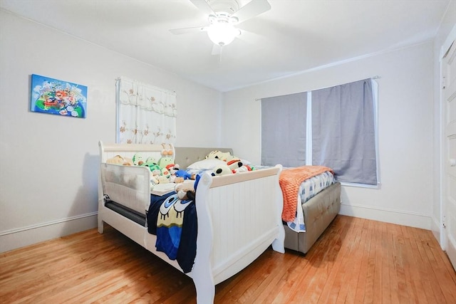 bedroom with ceiling fan, baseboards, and hardwood / wood-style floors