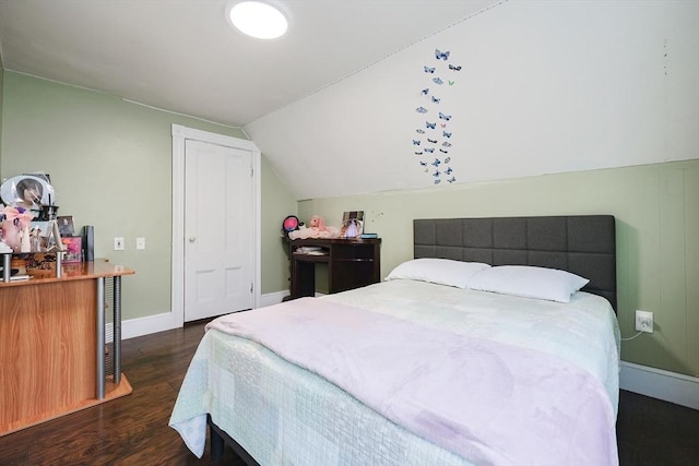 bedroom with vaulted ceiling, baseboards, and wood finished floors