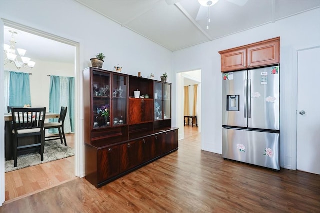 kitchen with ceiling fan with notable chandelier, glass insert cabinets, wood finished floors, and stainless steel fridge with ice dispenser