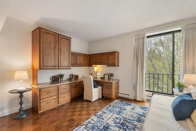 office space featuring baseboards, built in study area, and a baseboard radiator