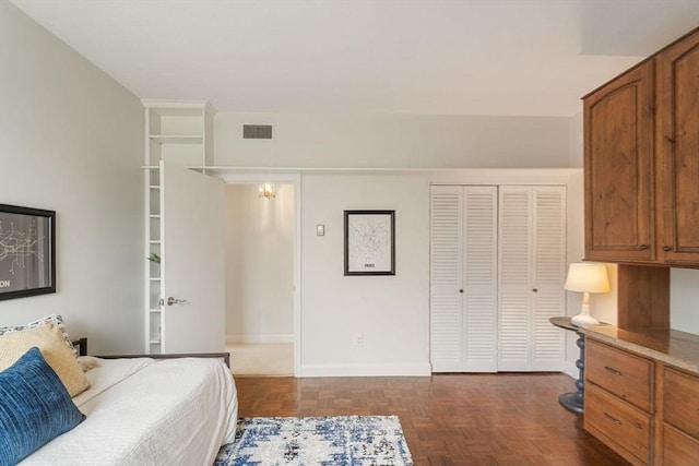 bedroom featuring baseboards, visible vents, and a closet
