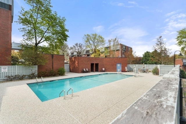 community pool featuring fence and a patio area