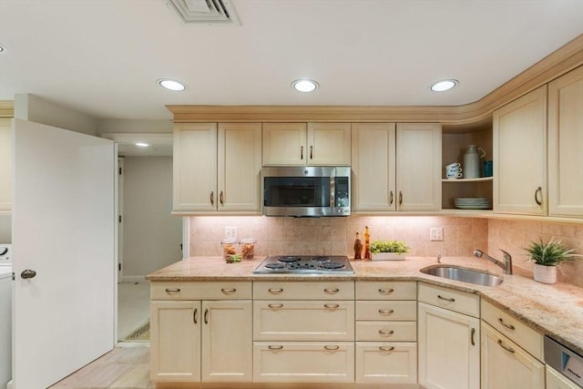 kitchen with open shelves, light stone counters, a sink, stainless steel appliances, and backsplash