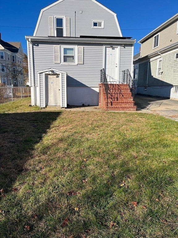 rear view of property featuring a yard