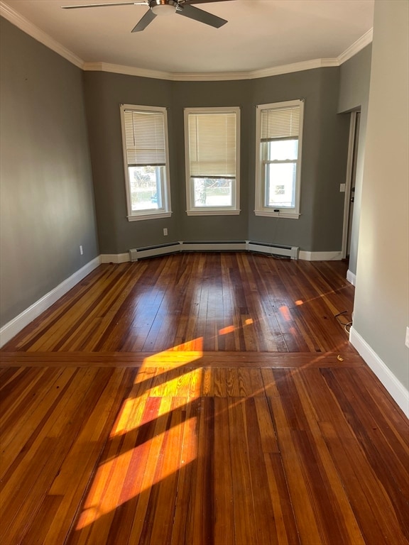 unfurnished room with dark hardwood / wood-style flooring, crown molding, and a wealth of natural light