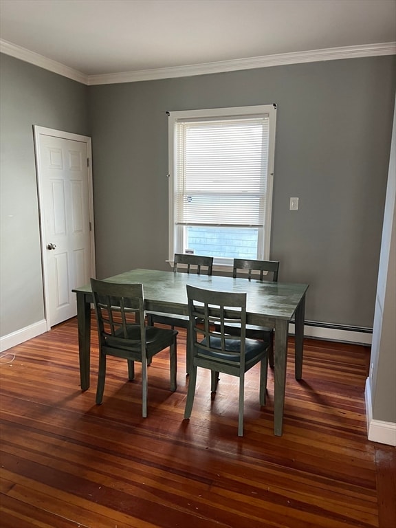 dining space featuring crown molding, baseboard heating, and dark wood-type flooring