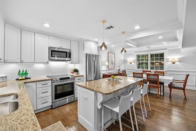 71 Weatherly Unit 71, Salem, MA 01970 - kitchen featuring stainless steel appliances, ornamental molding, dark wood finished floors, backsplash, and a kitchen island