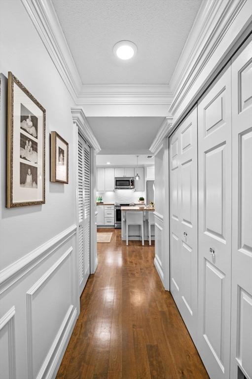 71 Weatherly Unit 71, Salem, MA 01970 - hallway featuring crown molding, dark wood-style flooring, and wainscoting