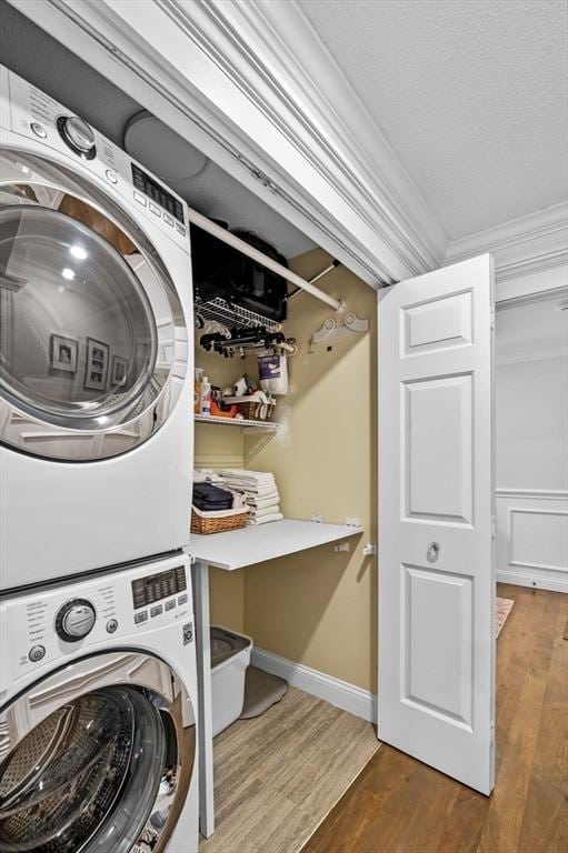 71 Weatherly Unit 71, Salem, MA 01970 - laundry area with stacked washing machine and dryer, wood finished floors, ornamental molding, and baseboards