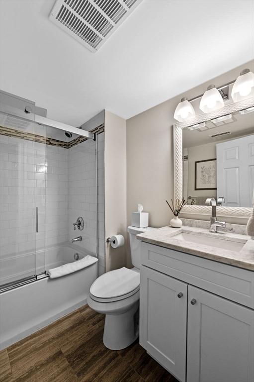 71 Weatherly Unit 71, Salem, MA 01970 - full bath featuring wood finished floors, vanity, shower / bath combination with glass door, and toilet