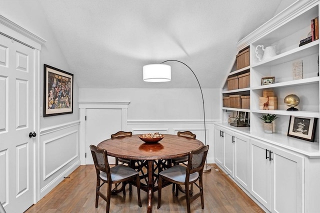 71 Weatherly Unit 71, Salem, MA 01970 - dining room featuring lofted ceiling, wood finished floors, a decorative wall, and a wainscoted wall