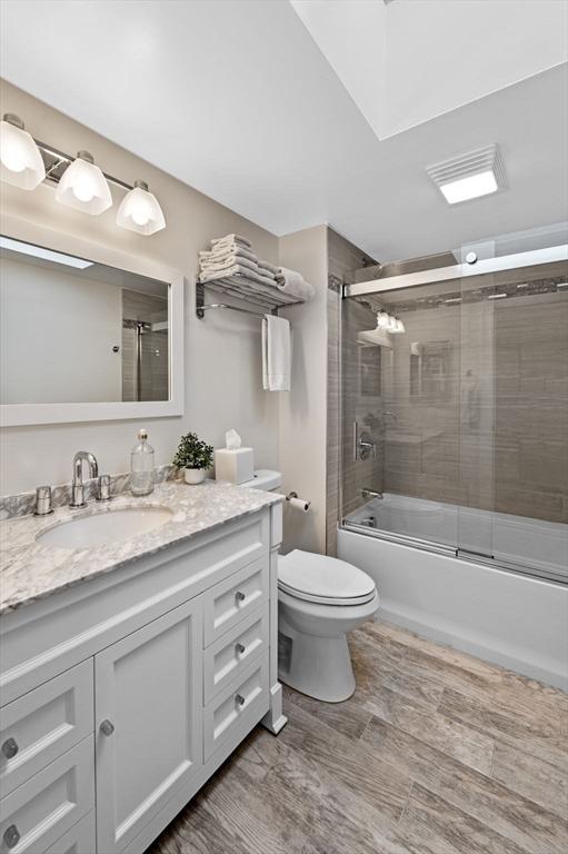 71 Weatherly Unit 71, Salem, MA 01970 - full bathroom featuring vanity, toilet, enclosed tub / shower combo, and wood finished floors