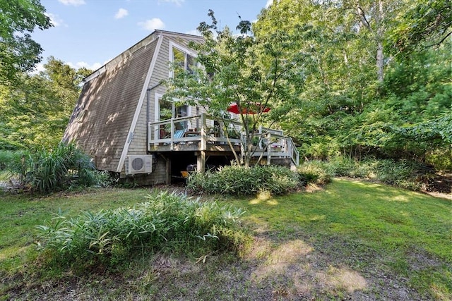 rear view of property with ac unit, a yard, and a deck