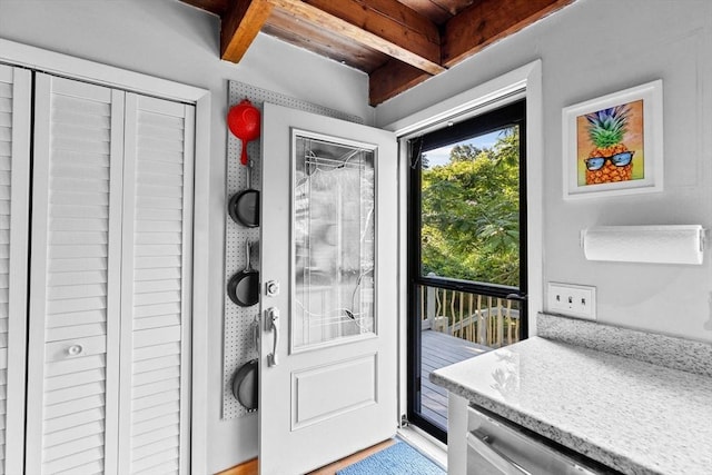 doorway to outside featuring beam ceiling