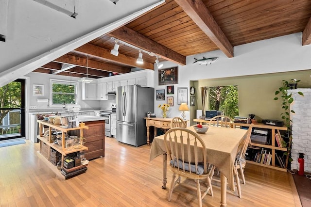 dining area with beamed ceiling, rail lighting, light hardwood / wood-style flooring, and wood ceiling