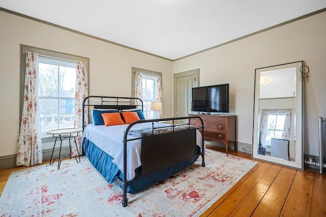 bedroom featuring crown molding, baseboards, and hardwood / wood-style flooring