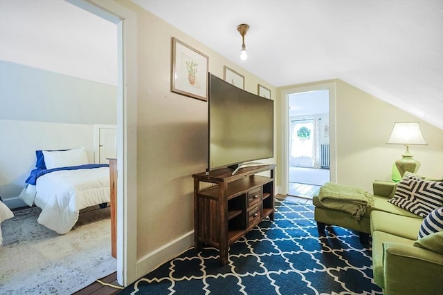 living room with vaulted ceiling, wood finished floors, and baseboards