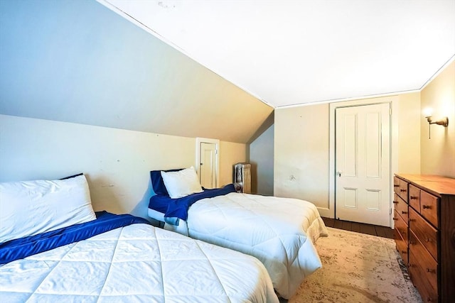 bedroom featuring lofted ceiling and wood finished floors