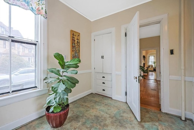 entrance foyer with baseboards, a wealth of natural light, and ornamental molding