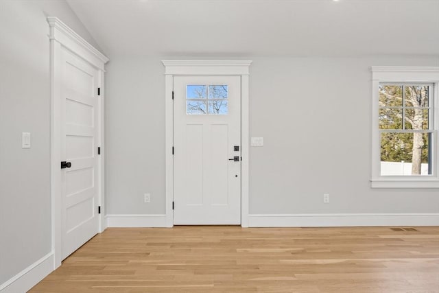 foyer with light wood-type flooring and vaulted ceiling