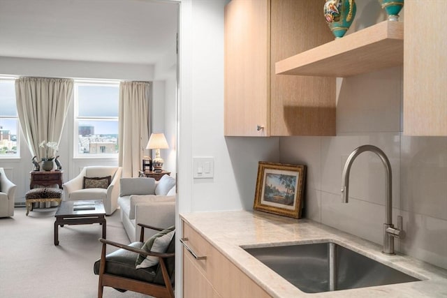 2 Commonwealth Ave Unit 15D, Boston, MA 02116 - kitchen featuring a sink, light brown cabinets, light stone countertops, tasteful backsplash, and open floor plan
