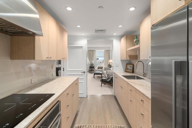 2 Commonwealth Ave Unit 15D, Boston, MA 02116 - kitchen featuring stainless steel fridge, a sink, wall chimney exhaust hood, light brown cabinets, and light wood-style floors