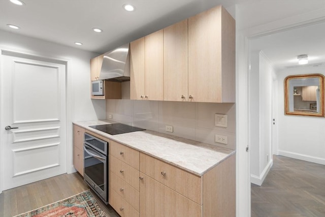 2 Commonwealth Ave Unit 15D, Boston, MA 02116 - kitchen with stainless steel oven, light brown cabinetry, wall chimney exhaust hood, black electric cooktop, and baseboards