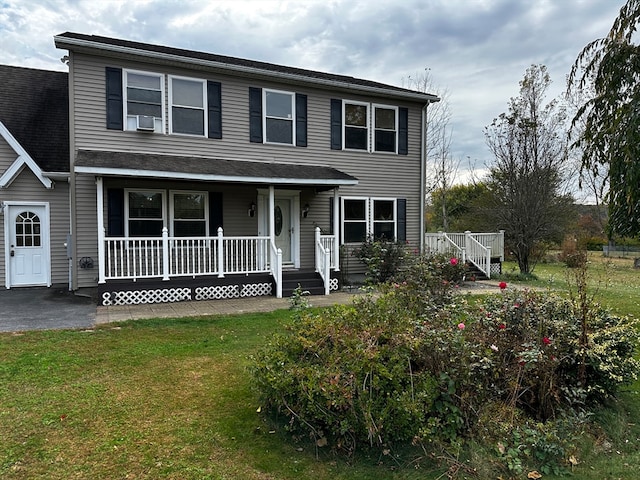 view of front of home featuring a porch, cooling unit, and a front lawn