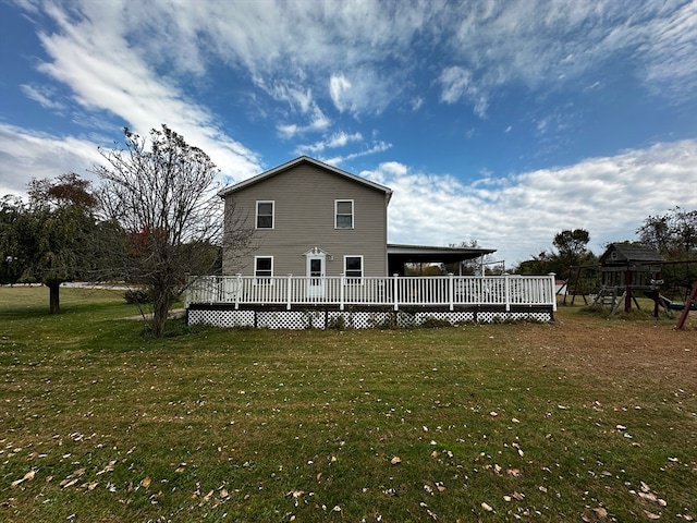 back of house featuring a playground, a lawn, and a deck